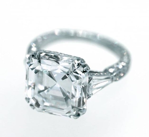 Asscher cut diamond ring flanked with side stones and micro pave diamonds in the band